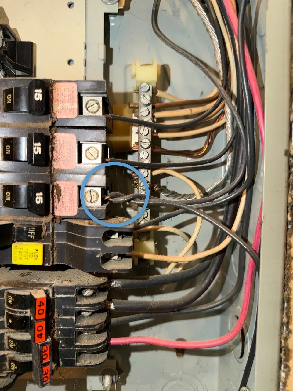 Open electrical panel with a breaker wiring defect circled during an Atlanta home inspection